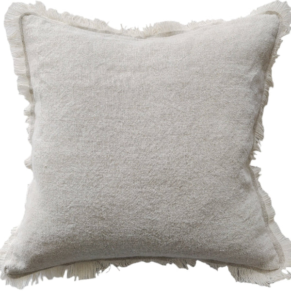 A square-shaped cushion with a fringed edge, in an oatmeal color, made from heavy weight texture French linen.