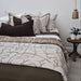 Bed with patterned bedding and pillows in a bedroom setting