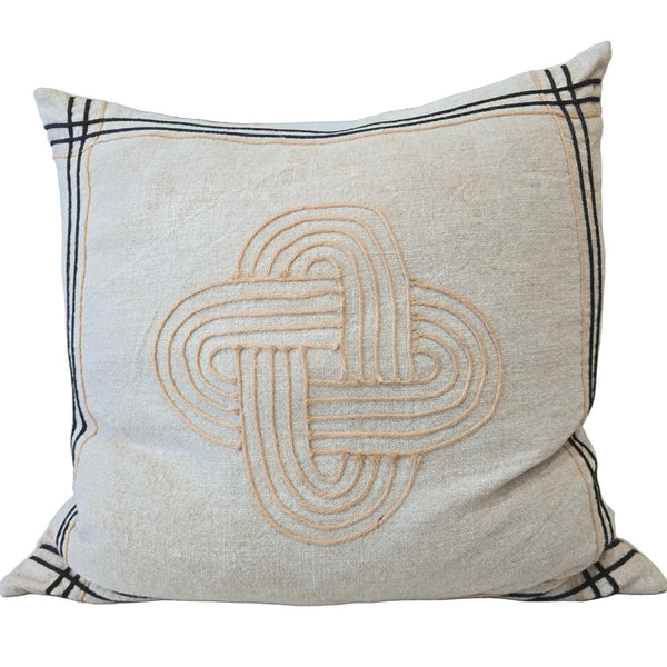 Decorative pillow with a Celtic knot design on a couch
