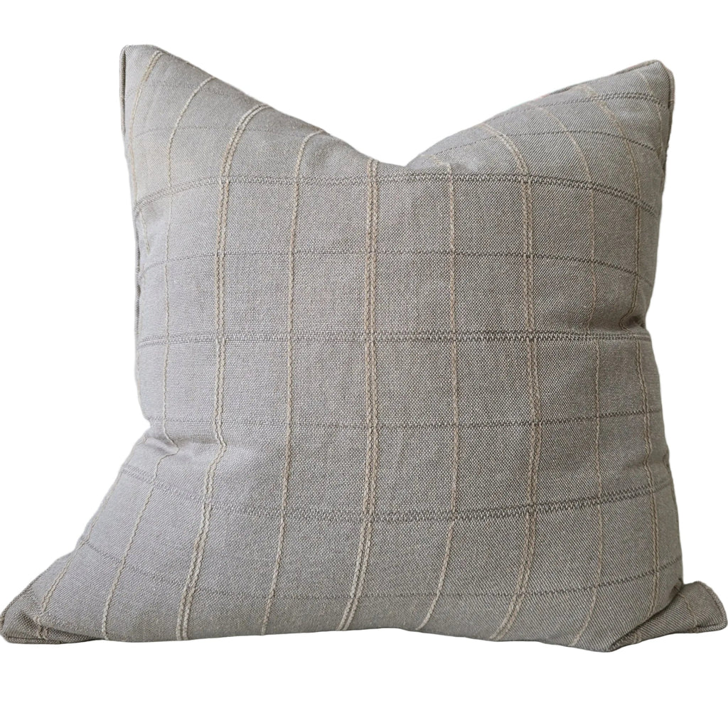 Plaid pillow on a sofa with a colorful abstract painting in the background