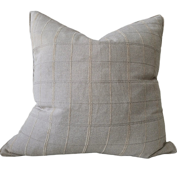 Plaid pillow on a sofa with a colorful abstract painting in the background