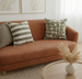 Brown sofa with patterned cushions in a living room setting