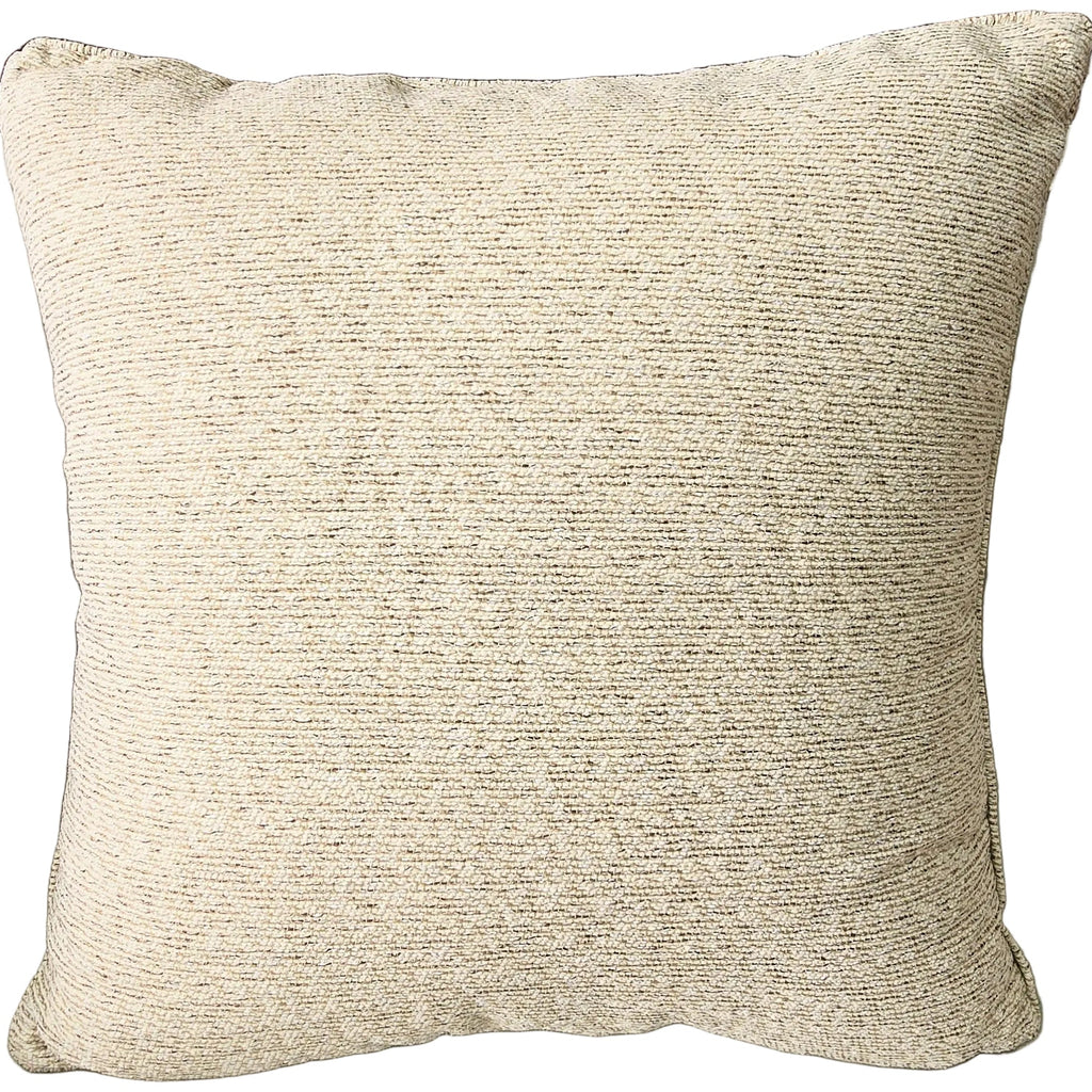 Outdoor Textured pillow on a sofa with a shelf and decorative items in the background
