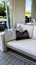Outdoor seating area with cushions on a wooden bench