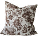Floral patterned pillow on a light gray sofa with a wooden table in the background