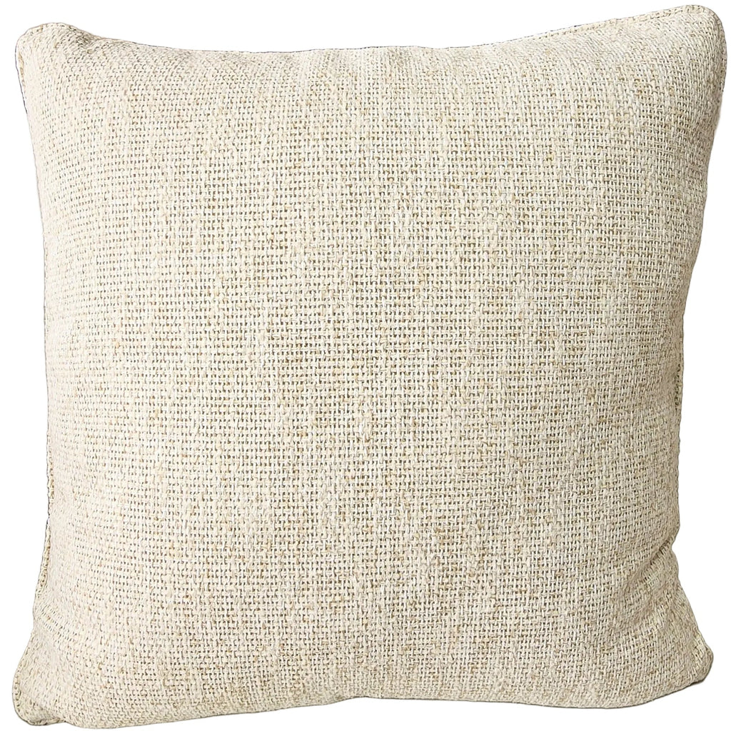 Outdoor Textured pillow on a sofa with a wooden side table and decorative items in the background