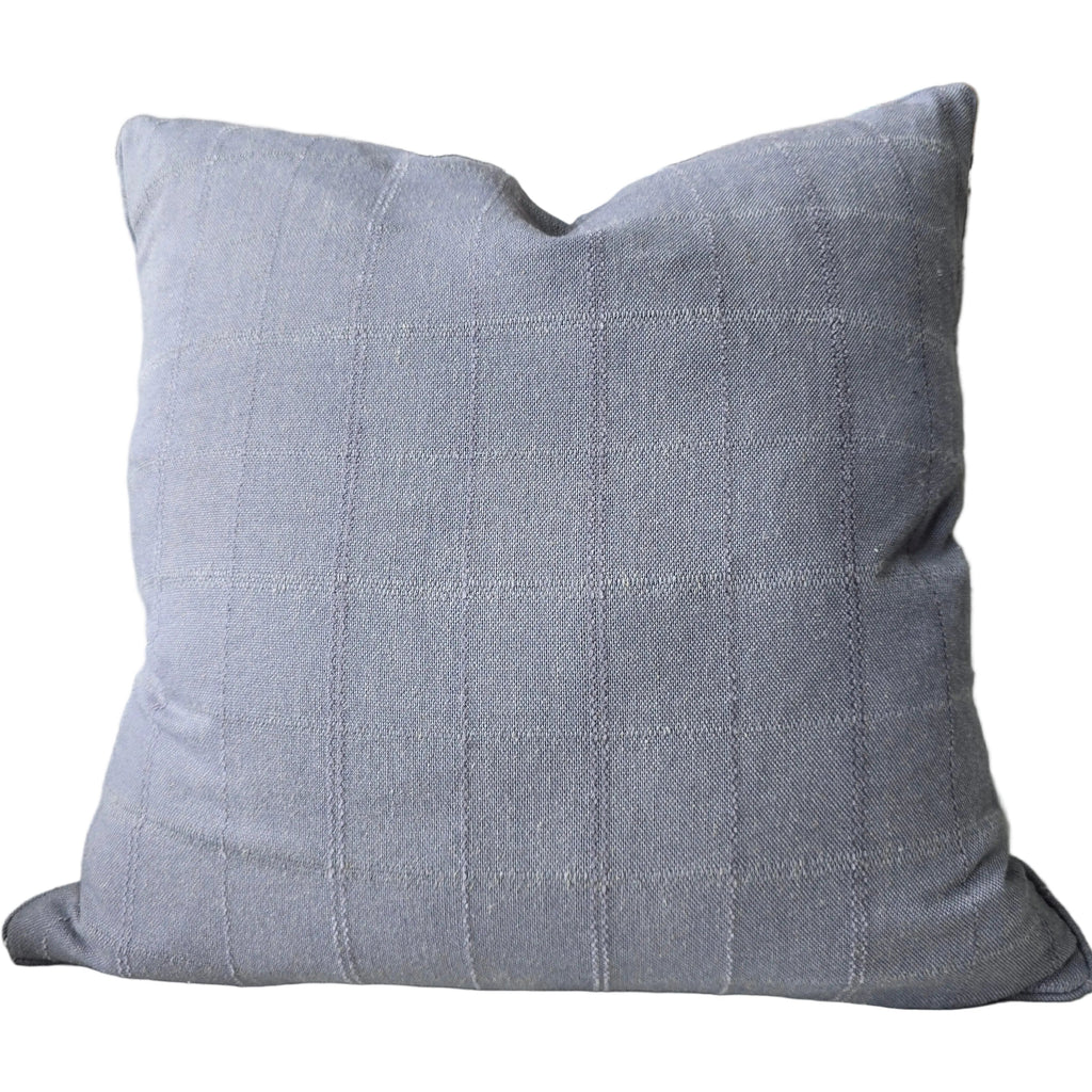 Gray pillow on a couch with a colorful abstract painting in the background