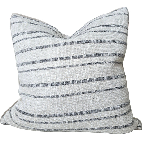 Striped pillow on a sofa with other decorative pillows in the background