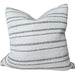 Striped pillow on a sofa with other decorative pillows in the background