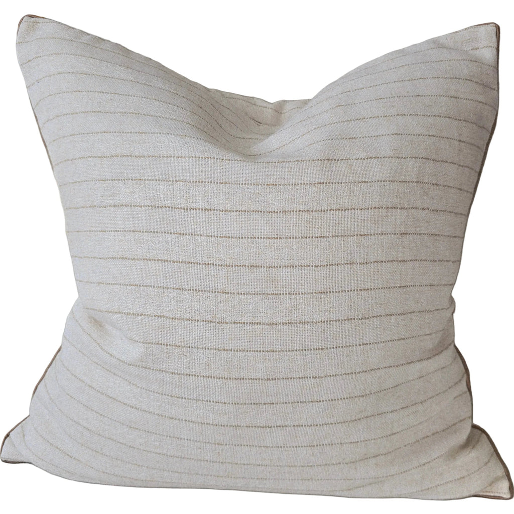 Textured beige pillow on a sofa with a neutral background
