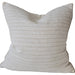 Textured beige pillow on a sofa with a neutral background