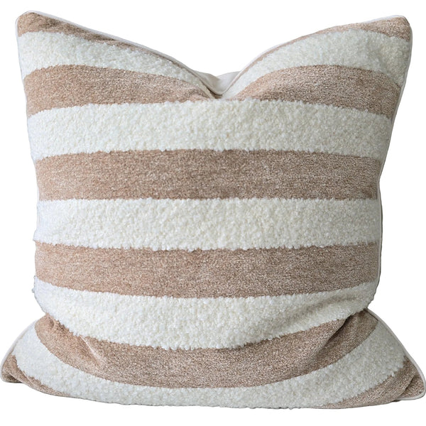 Striped pillow on a sofa with a wooden table in the background