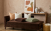 Brown sofa with patterned cushions in a living room setting.