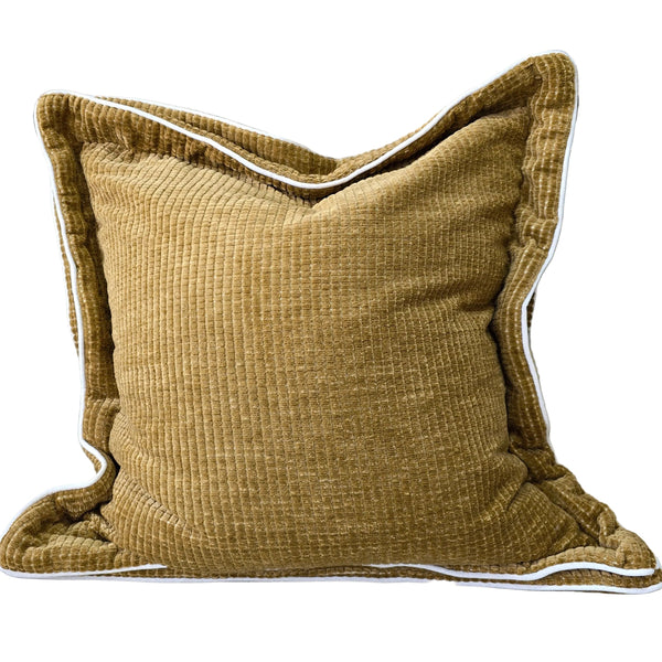 Gold textured pillow on a gray sofa with a checkered blanket and wooden chair in the background.